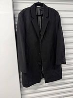 Full view of black Michael Kors overcoat hanging, front side