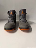 Front view of both sneakers showing uppers, laces, and orange trim