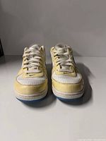 Front view of both sneakers showing laces, perforated toes and yellowing