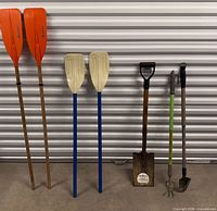 Full group view showing all paddles and garden tools
