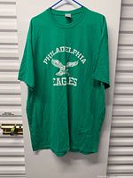 Front view of green Philadelphia Eagles T-shirt hanging