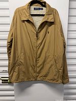 Full view of tan Polo Ralph Lauren jacket front with zipper and pockets