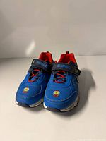 Front view of both sneakers showing toe details, strap logos, and overall condition