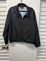 Full view of black Tommy Hilfiger coat hanging