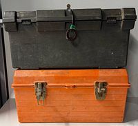 Two stacked toolboxes, green plastic on top, orange metal below