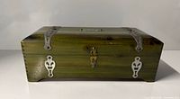 Front view of green wood jewelry box with metal strapwork and brass latch