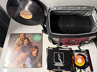 Bag filled with 45s, two 12-inch vinyls, Floating Opera sleeve, small stack of 45s