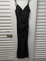 Front view of full-length black dress on hanger