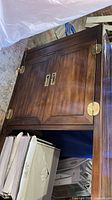 Full view of entertainment center showing cabinet doors and brass hardware
