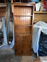 Full frontal view of tall pine bookcase showing shelves and lower cabinet