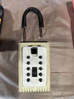 Off-white Master Lock key safe with open shackle and keypad visible