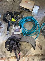 Group shot: teal hose, nozzles, grease pump, gloves, wall holder, straps