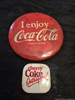 Front view of both Coca-Cola buttons