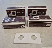 Four unopened boxes of coin flips with one sample flip displayed