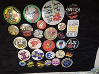 Full set of 28 pin-back buttons on black background