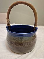 Front view showing vessel glaze and wooden handle