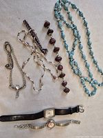 Entire lot showing two watches and five necklaces