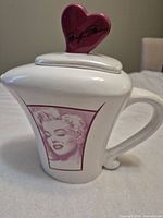 Front angled view of teapot showing portrait and heart lid