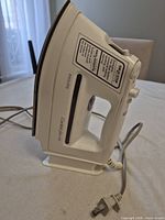 Left side profile of Philips white steam iron showing brand, Comfort series marking, grey power cord