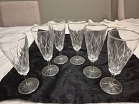 All six flutes upright on black cloth showing overall condition