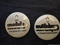 Front of both buttons showing English and French designs