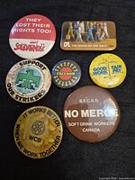 Front view of all seven buttons displaying slogans and graphics
