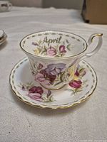 Cup and saucer front view showing pattern and April script