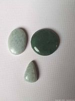 Three aventurine cabochons on surface