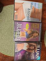 Front view of three sealed workout DVDs showing titles and cover art