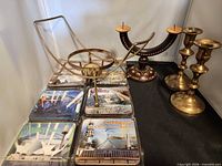 Group shot of all items: brass candlesticks, painted candelabrum, warmer stand, eight packs of Australian coasters