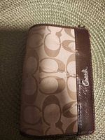 Front of Coach wallet showing canvas pattern and leather trim