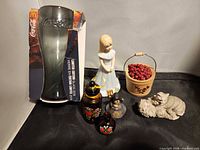 Group shot of all seven items including boxed Coca-Cola glass, Enesco figurine, two mini bottles, angel, kitten figurine, berry bucket
