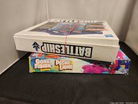 Side view of stacked Battleship and Gone Fishing game boxes