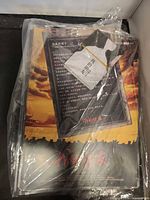 Plastic-wrapped stack of posters and lanyard pass