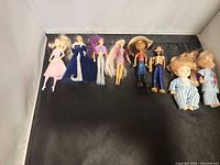 Group shot of all eight dolls laid out on black surface