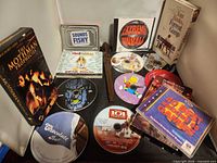 Overall view of VHS tapes, CDs, PC games, card game tin and recorder