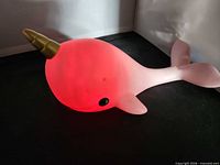 Narwhal night light illuminated red, side view