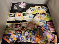 Overview of spread showing Pokémon trainer cards, Yu-Gi-Oh trap cards, Transformers and OverPower character cards