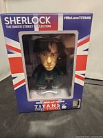 Front of boxed Sherlock Titans vinyl figure