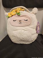 Front view of Sophie Easter Basket plush showing facial features and handle with flowers