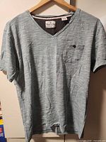 Front view of heather blue Thread & Cloth V-neck T-shirt on hanger