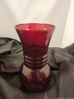 Front view of ruby red glass vase displaying shape and color