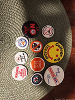 Top view of eleven slogan pinback buttons on mat