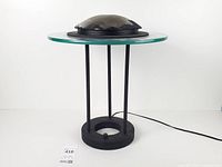 Full view of lamp showing glass disc, metal supports, base and power cord