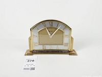 Front view of Bulova arched brass mantel clock with Roman numeral dial