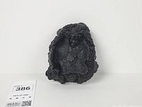 Front view of black lava rock–resin ashtray with Pele relief