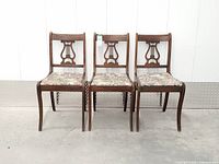 Front view of three matching lyre-back chairs