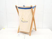 Full view of collapsible wood X-frame hamper with liner installed