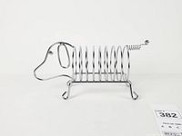 Side view of chrome dachshund holder showing spiral body and head profile