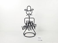 Front view of black wire cowboy wine holder showing coils and figure